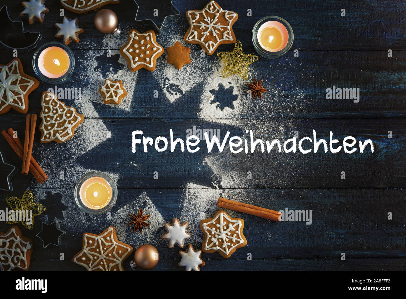 Gingerbread Cookies Spices And Burning Candles On A Star From Icing Sugar On A Dark Blue Wooden Background German Text Frohe Weihnachten Meaning Me Stock Photo Alamy