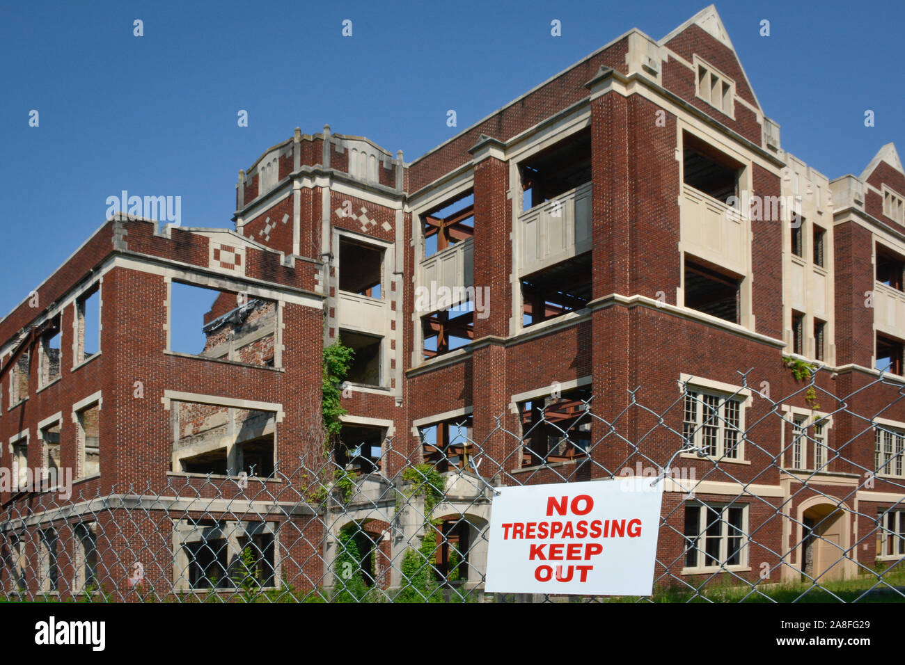 The old landmark of Hattiesburg, MS High School building, badly damaged by arsonists, fenced with Keep Out signs with be restored to senior apartments Stock Photo