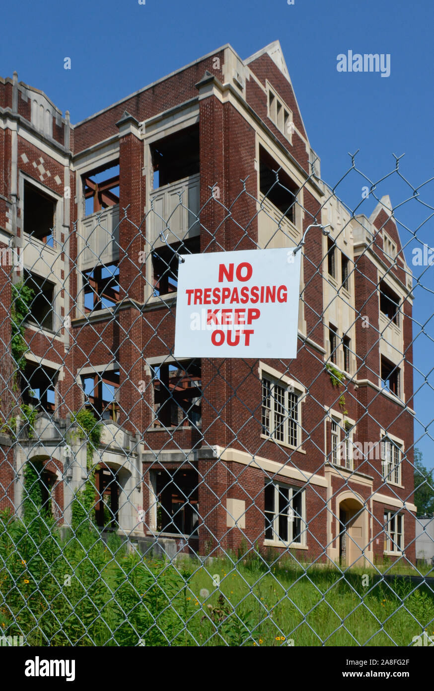 The old landmark of Hattiesburg, MS High School building, badly damaged by arsonists, fenced with Keep Out signs will be restored to senior apartments Stock Photo