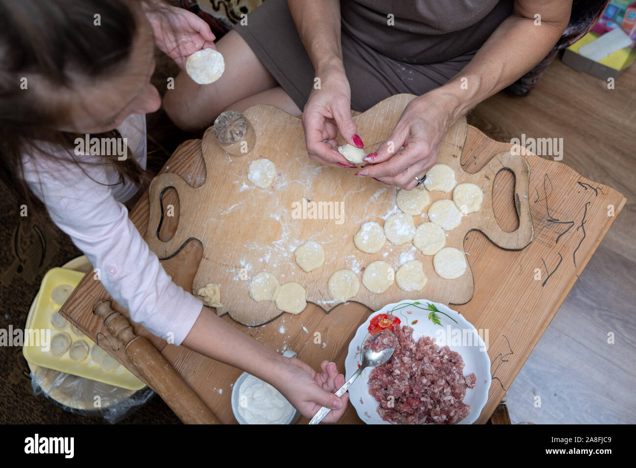 woman making dumpling New Year reunion holiday mom and daughter hand Stock Photo