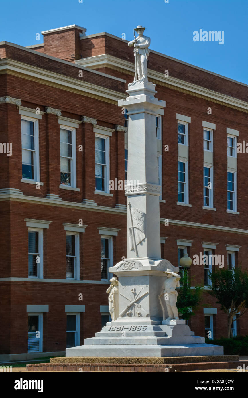 A tall marble monument with a sculpture of a Confederate Solider atop, beside the Forrest County Courthouse in Hattiesburg, MS Stock Photo