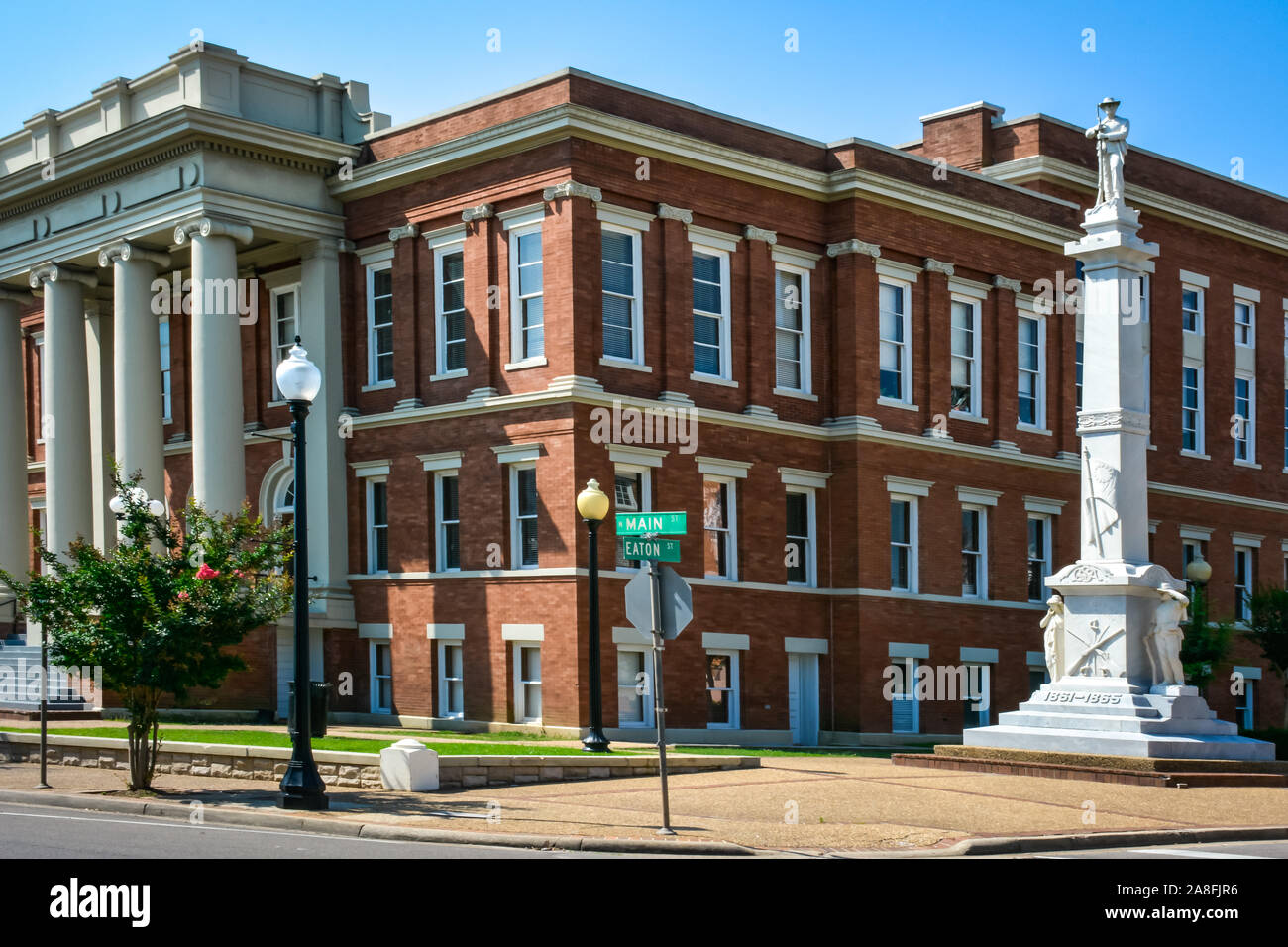 A tall marble monument with a sculpture of a Confederate Solider atop,  stands beside the Forrest County Courthouse in Hattiesburg, MS, USA Stock Photo
