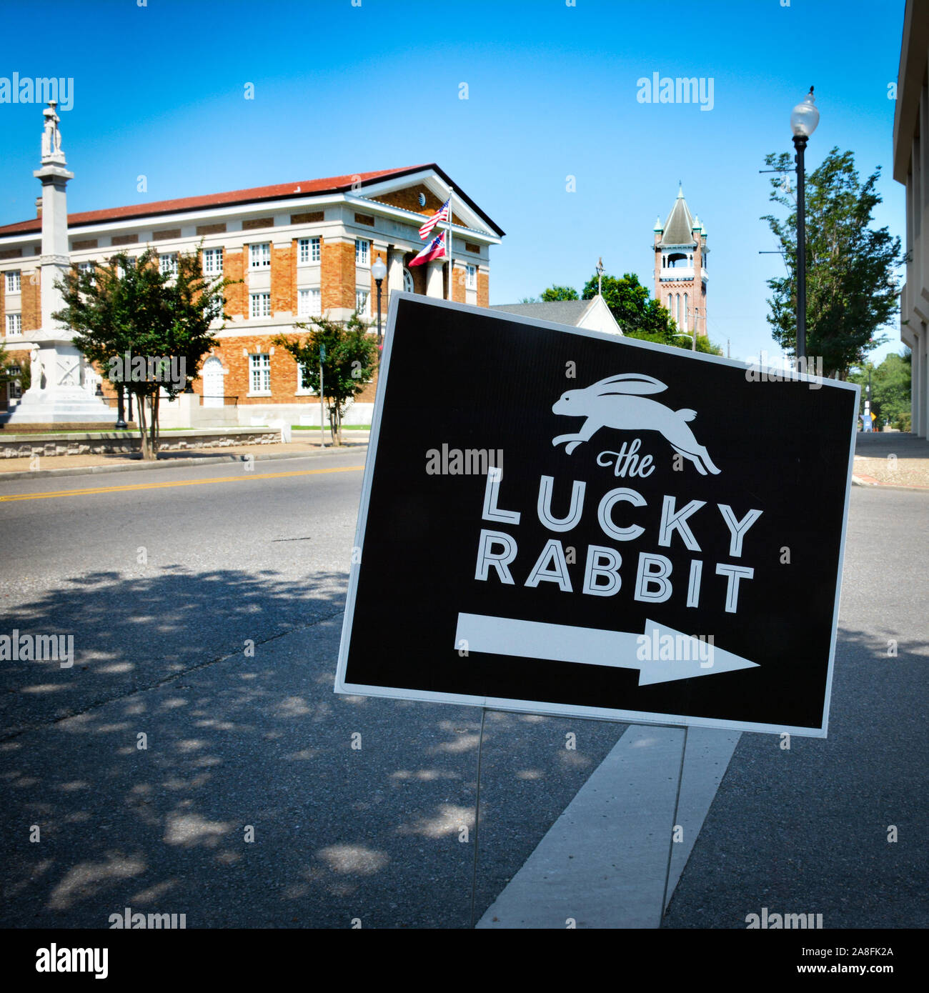 A vintage consignment event monthly at the Lucky Rabbit, sign with arrow and jumping rabbit clip art at corner in downtown Hattiesburg, MS, USA Stock Photo