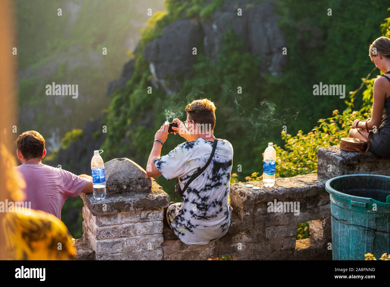 Tourists watch the sun go down at the top of Mua Caves during a beautiful sunset in Northern Vietnam Stock Photo
