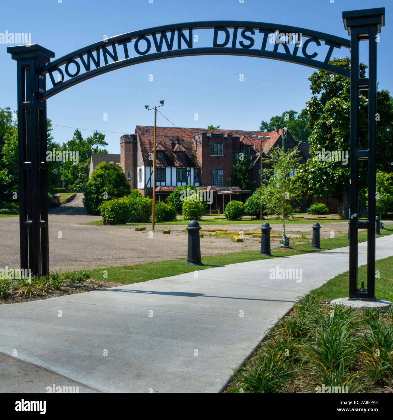 An overhead black metal cutout design sign reading downtown district in newly regenerated areas