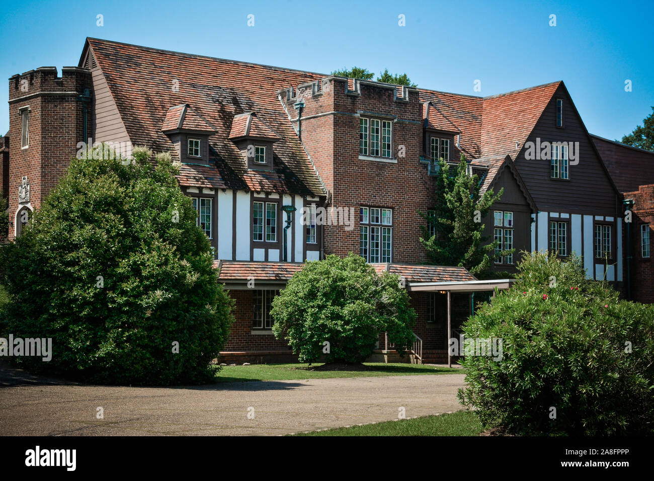 Facade of a Tudor revival style building in brick with Norman accents