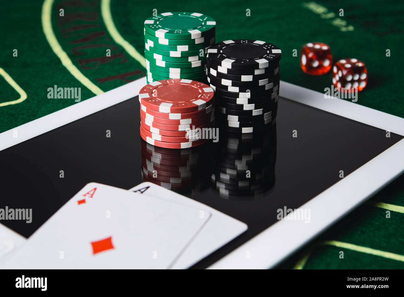 Online poker gambling concept. Chips and poker card on a digital tablet Stock Photo