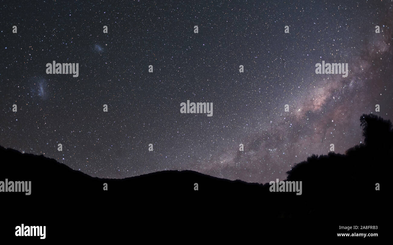The Milky Way galaxy and Magellanic Clouds seen above the silhouetted ...