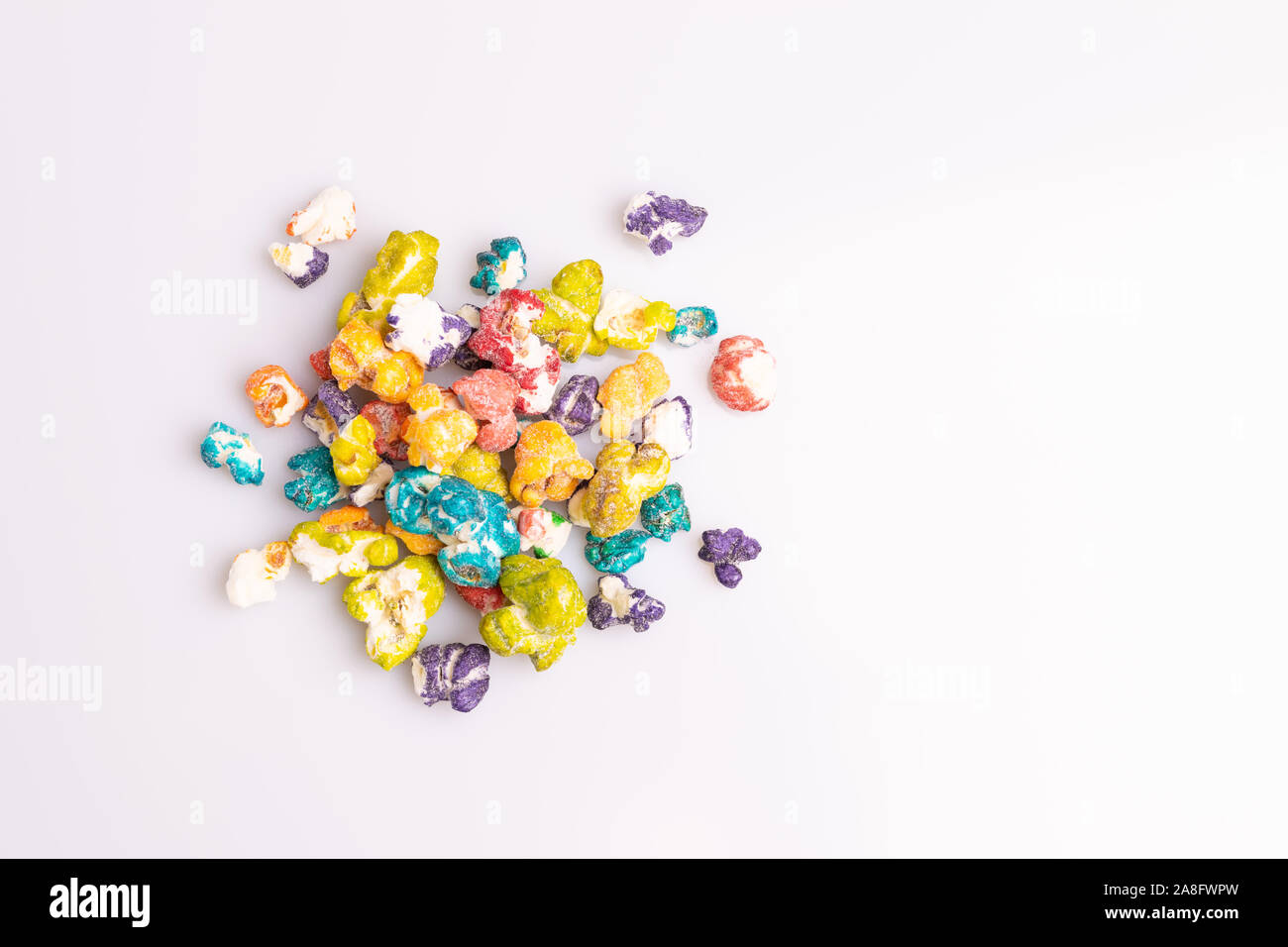 Colored Popcorn candy isolated on white background, soft light, studio shot, copy space. Junk food, fruit flavored popcorn. Colorful, multicolor, cand Stock Photo