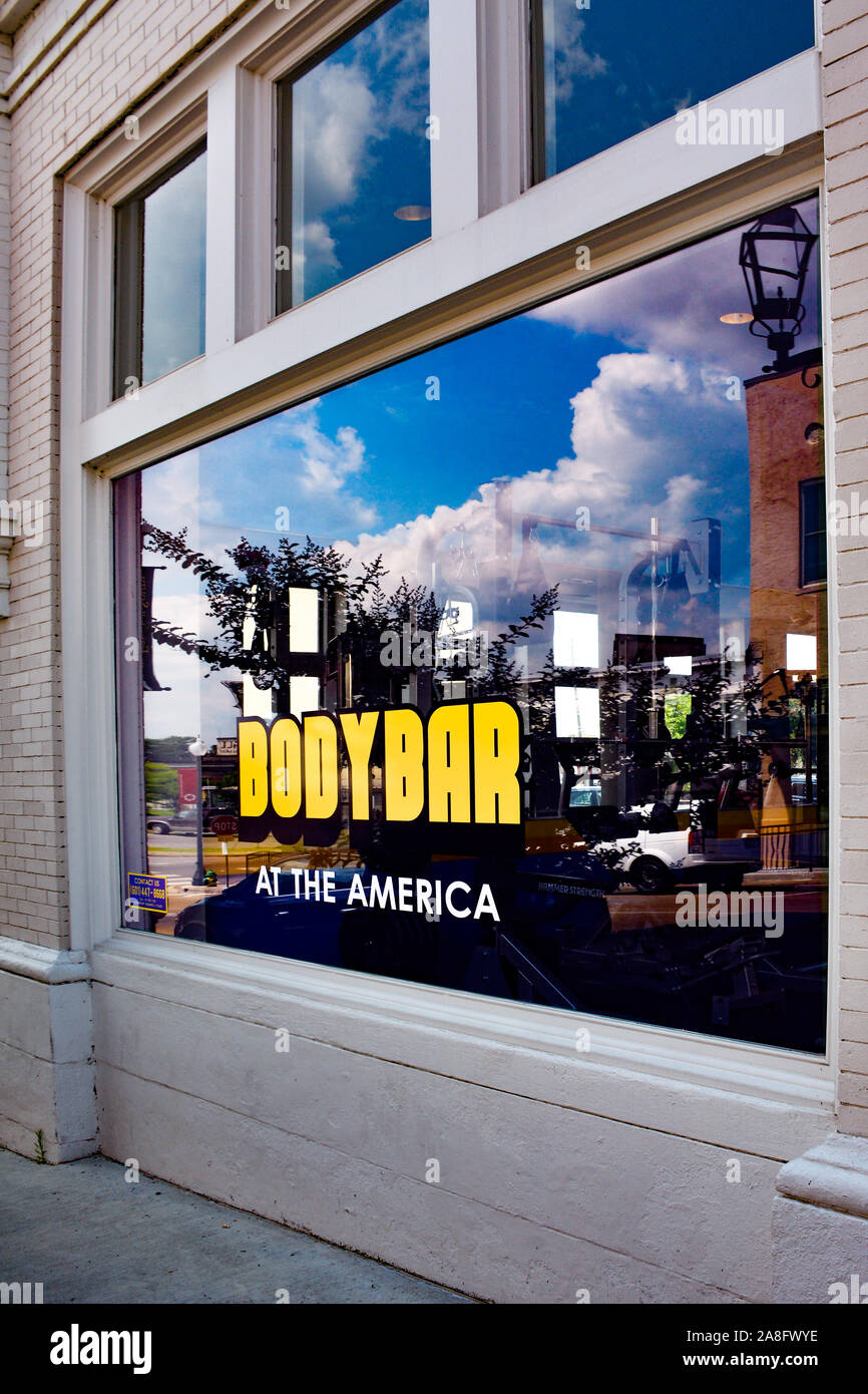 Vintage building with Big window painted in yellow Body Bar, at the America, a gym and fitness studio in downtown Hattiesburg, MS, USA Stock Photo