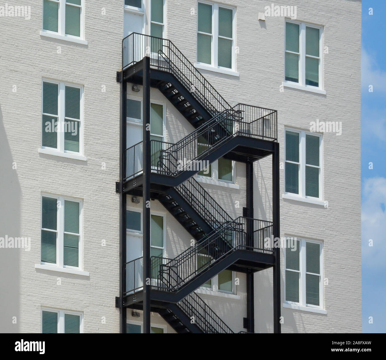 A contrast between a modern black iron fire escape on a Vintage white brick building with minimalist accents in Hattiesburg, MS, USA Stock Photo