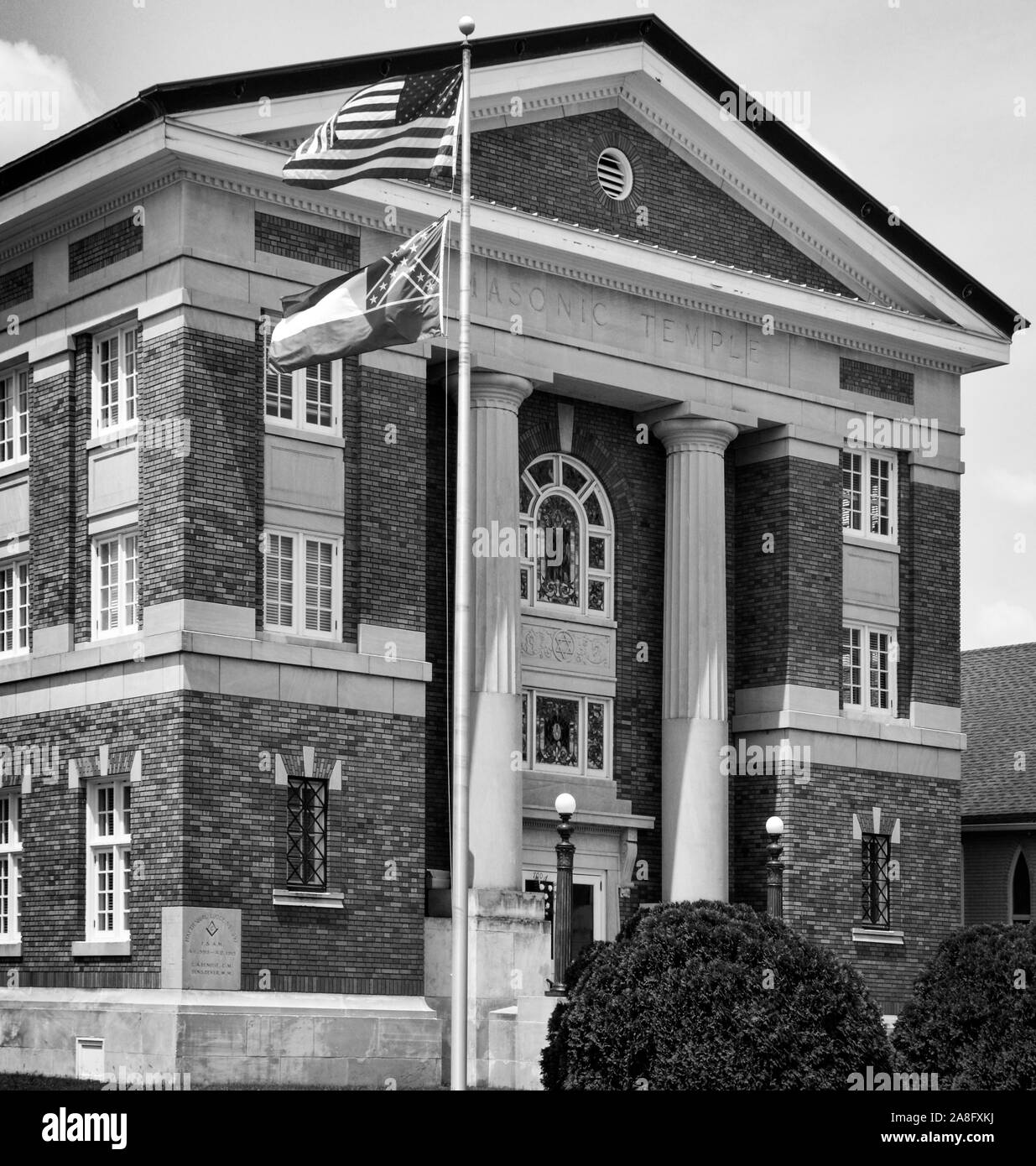 American Flag and the Mississippi State Flag wave in front of the Forrest County Justice Court, formerly a Masonic temple in downtown Hattiesburg, MS Stock Photo