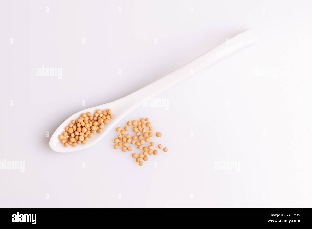 Yellow mustard seeds isolated on white background, soft light, studio