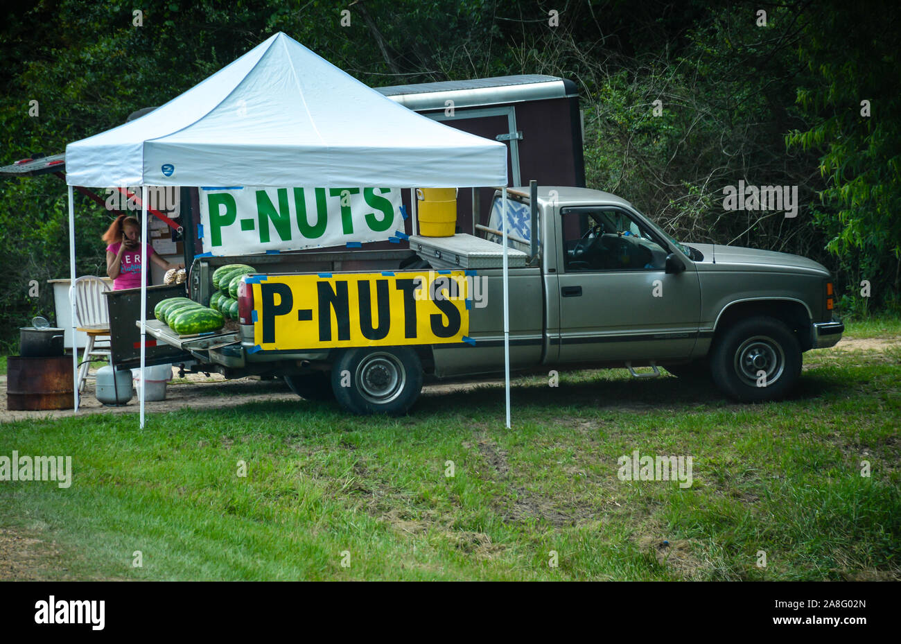A pick up truck tailgate and tent shade the PNuts and watermelons for