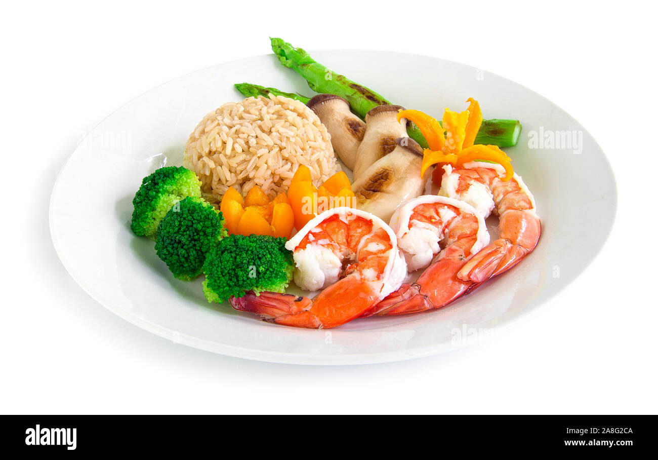 Healthy food Brown rice with shrimp, Broccoli, Grill Asparagus and king oyster mushrooms decorate with carved chili, tomato side view Stock Photo