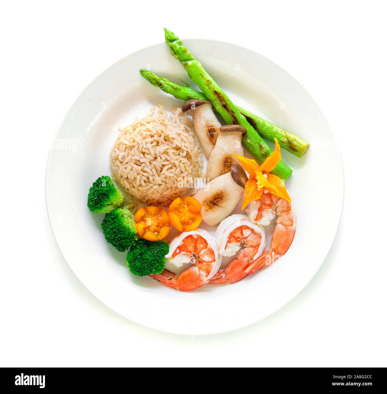 Healthy food Brown rice with shrimp, Broccoli, Grill Asparagus and king oyster mushrooms decorate with carved chili, tomato top view Stock Photo