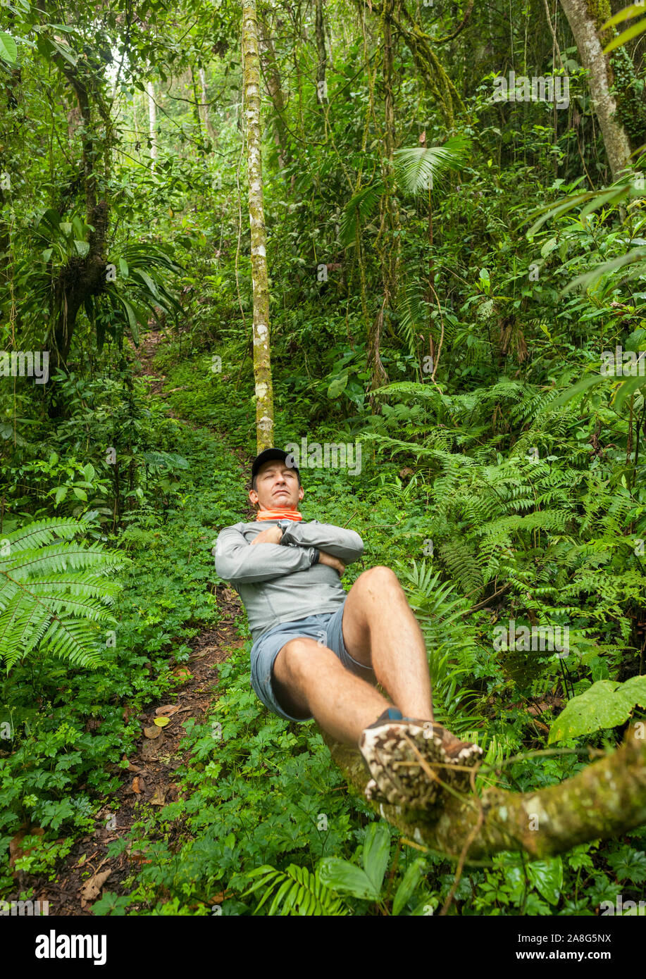 Man resting on a vine in the Pichinde region of the Parque Nacional Natural Los Farallones De Cali in the Valle de Cauca, Colombia. Stock Photo