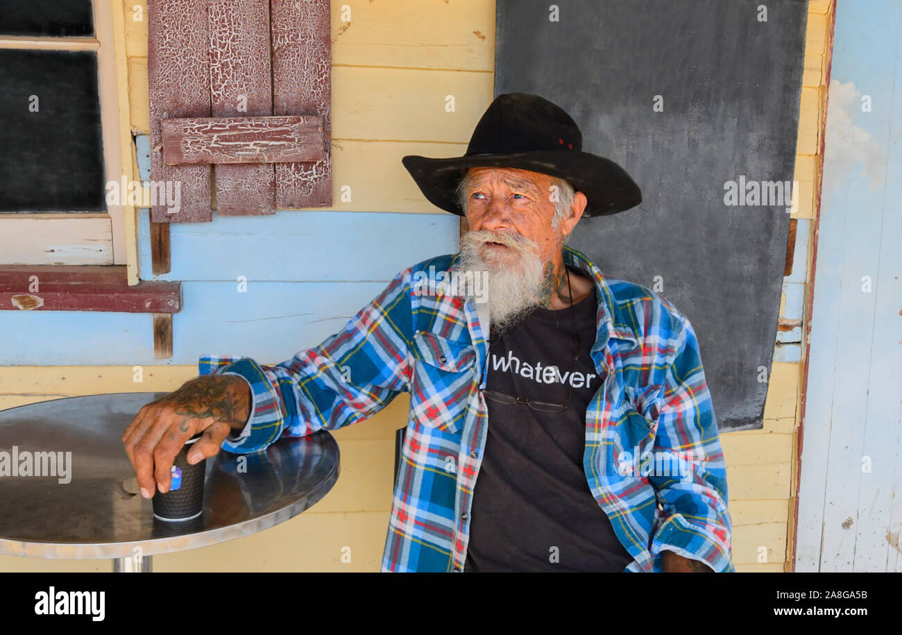 Candid portrait of a bearded old timer sitting outside the iconic Hebel Hotel, Balonne Shire, New South Wales, NSW, Australia Stock Photo