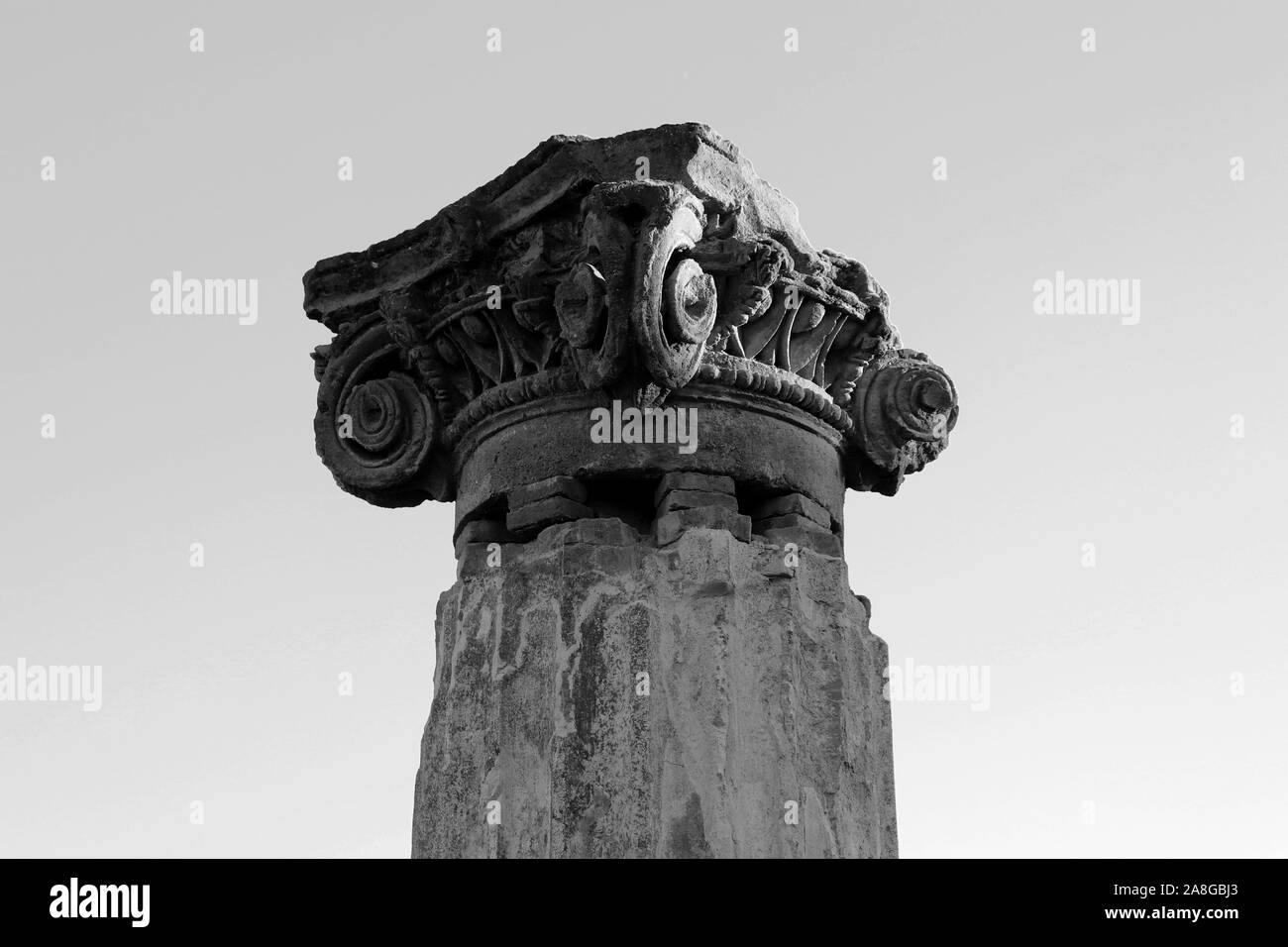 Ancient roman greek column with broken chapiter. Pompeii, Italy. Black and white photo Stock Photo