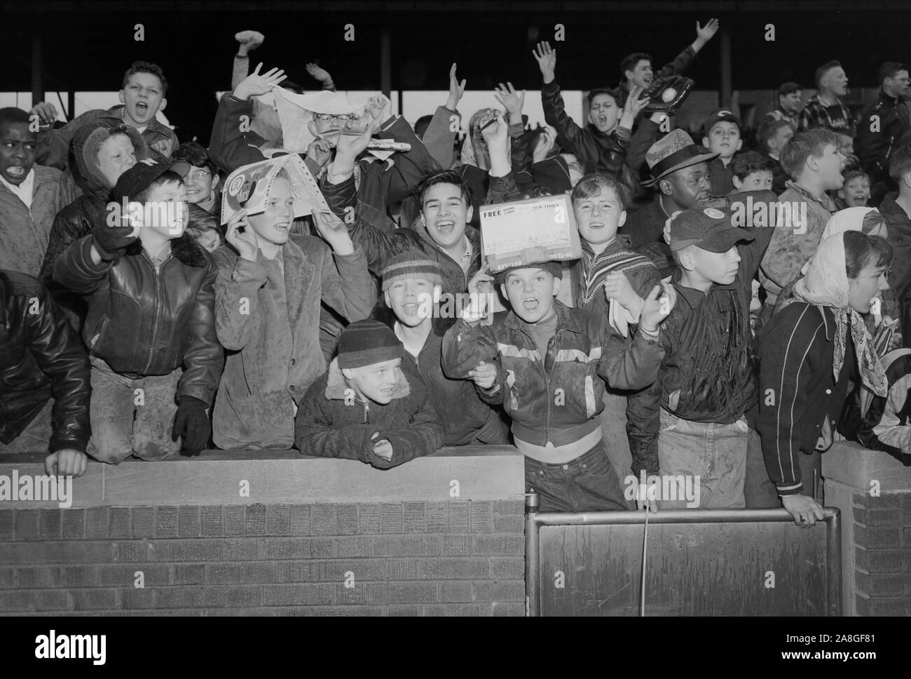 A crowd of youths scream and yells at the field gate of Chicago's Wrigley Field before a Cubs game, ca. 1940 Stock Photo