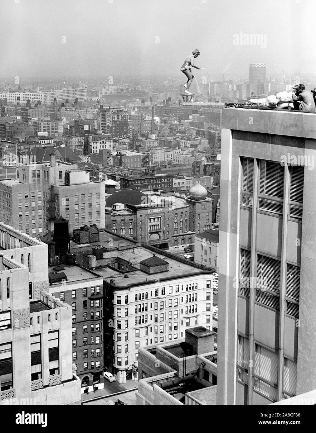 A woman jumps rope on a platform perched high on a Chicago skyscraper on the city's north side, ca. 1960. Stock Photo