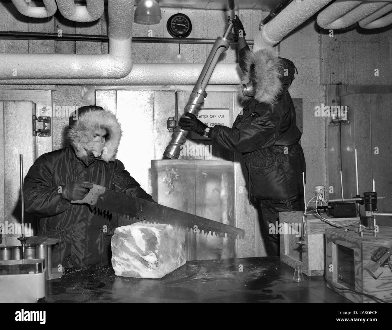 Workers in a research lab in Chicago work with block of ice in an super cold environment, ca. 1955. Stock Photo