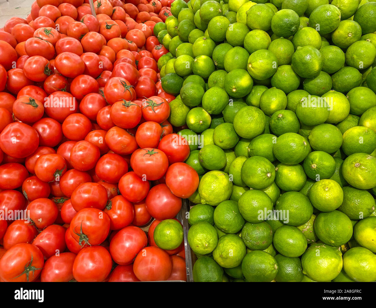 Pile of red tomato and lime for sale at hypermarket Stock Photo - Alamy