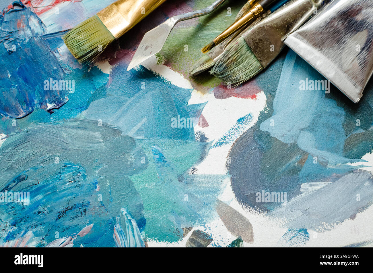 Artist paint brushes and oil paint tubes on wooden palette. Texture mixed  oil paints in different colors. Instruments and tools for creative leisure  Stock Photo - Alamy