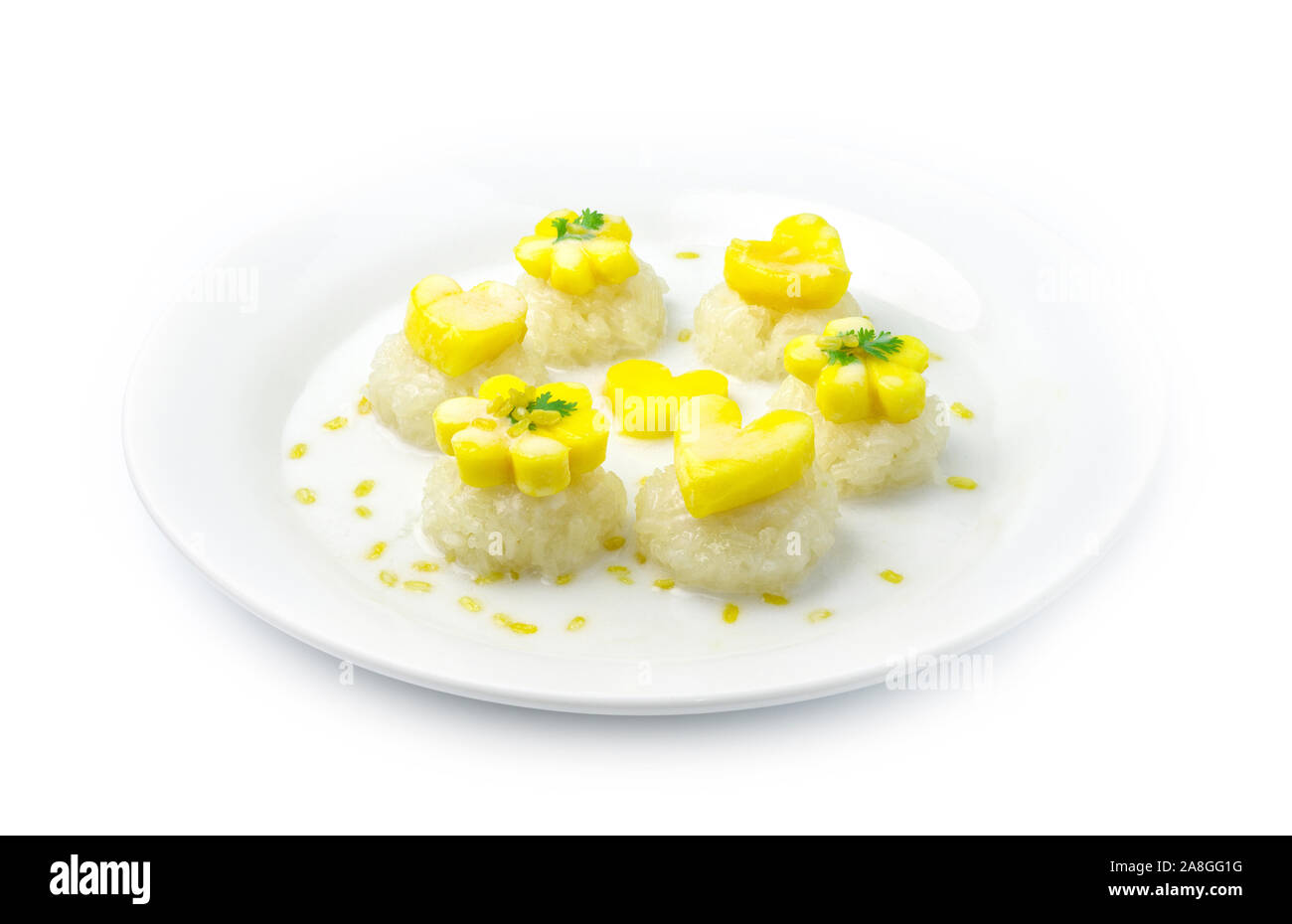 Sticky rice with mango Thai Dessert popular in one  bite style and carved Mango hearts and flower shape served with Coconut milk cream sauce and Golde Stock Photo