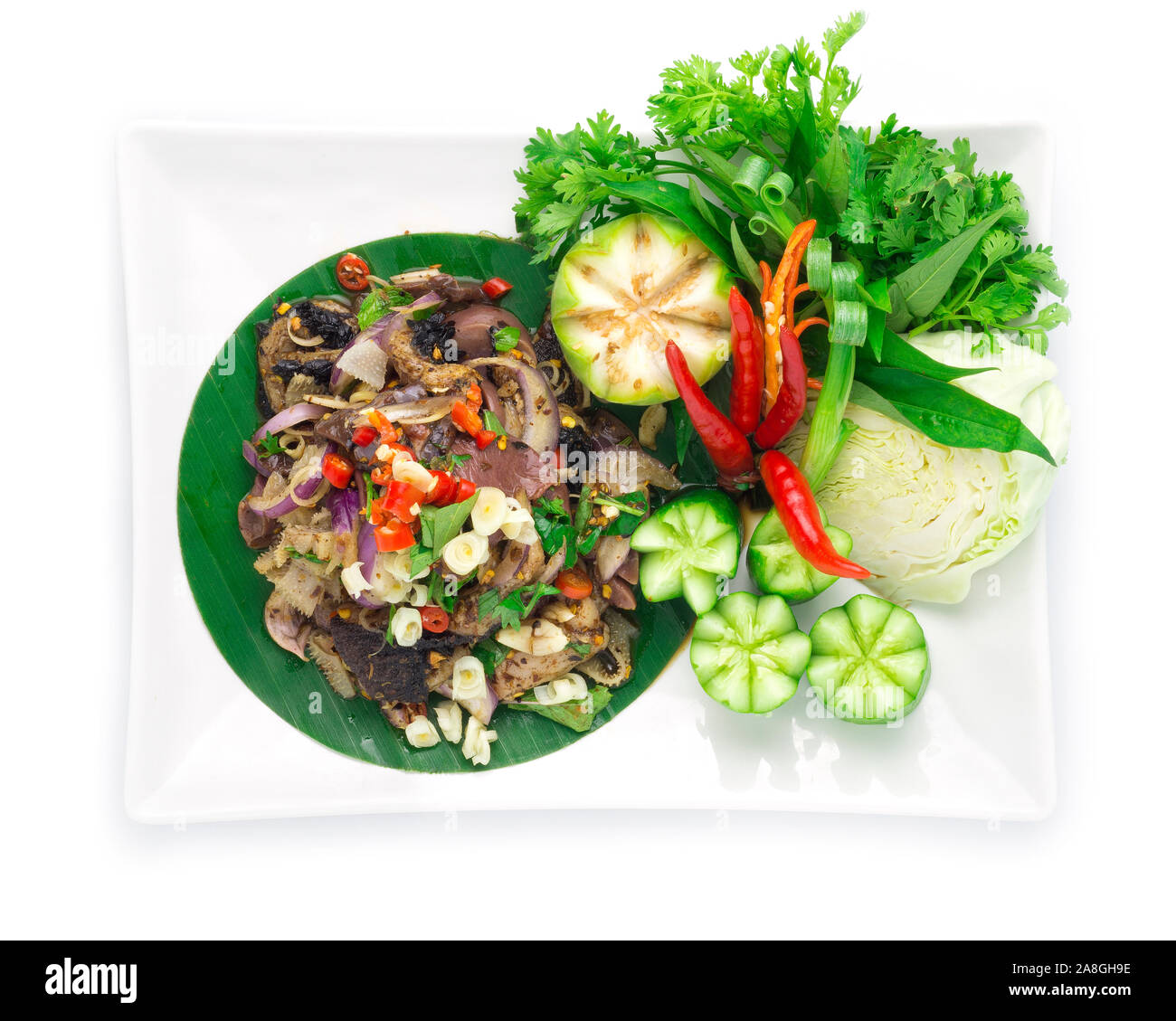 Spicy Raw Offal Beef Salad with ingredient Spicy Herbs Thai Food Popular in Northern Style decorate with carved cucumber and vegetables top view Stock Photo