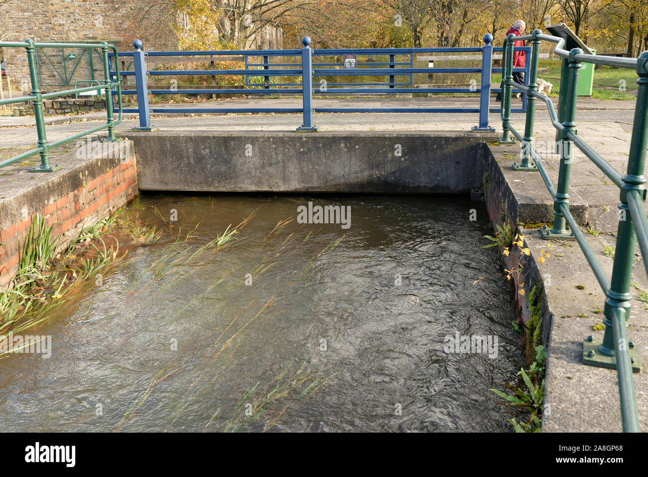 Canal feeder water at high level flowing under concrete footbridge in