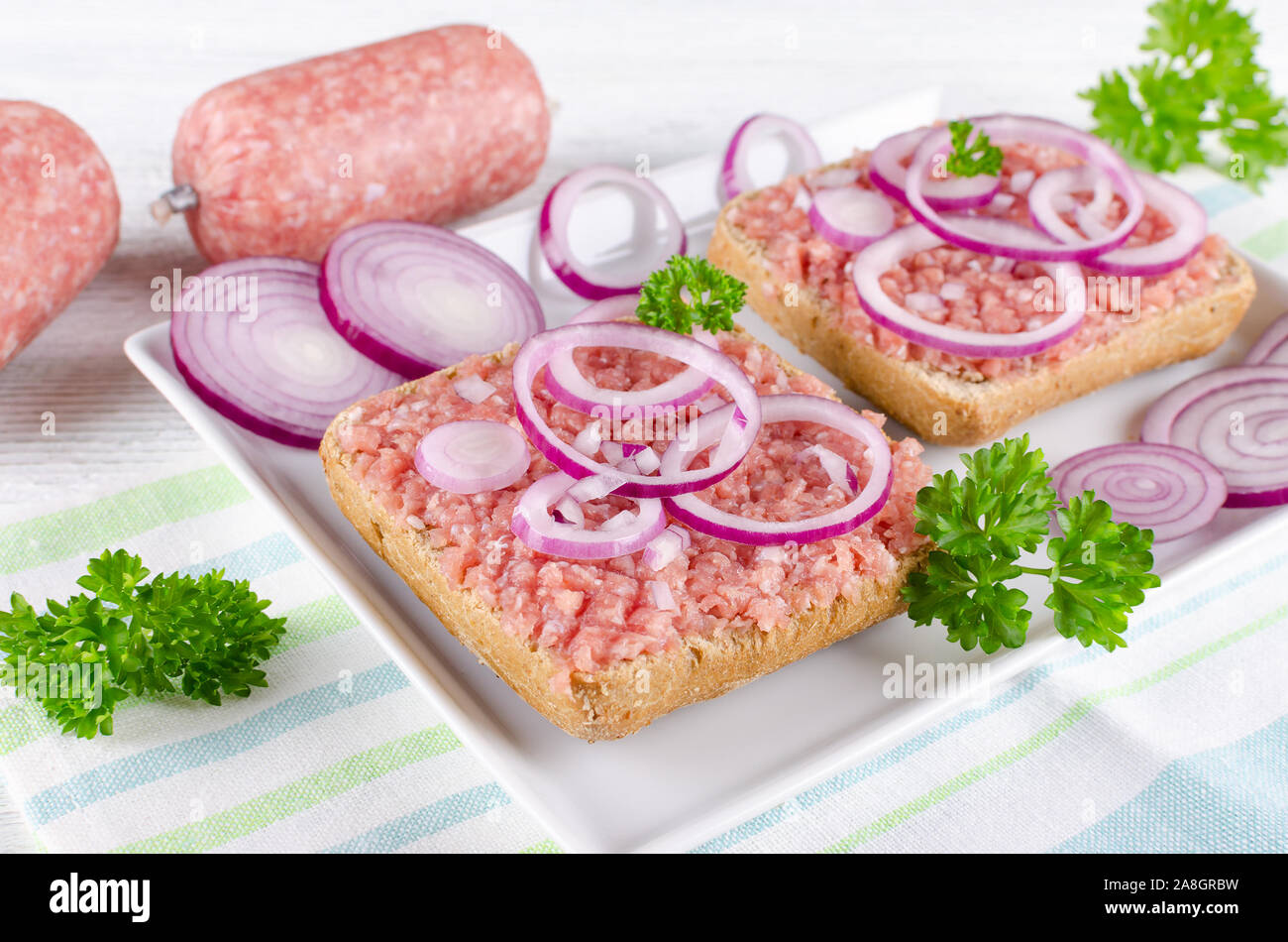 german sandwich with mett ground pork, bun and raw meat with onion and parsley, closeup Stock Photo