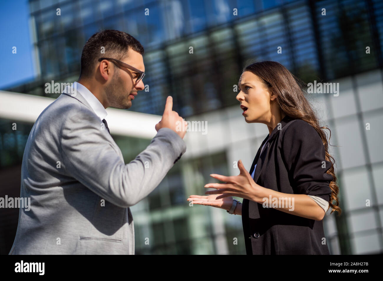 Business colleagues are arguing outside the company building. Stock Photo