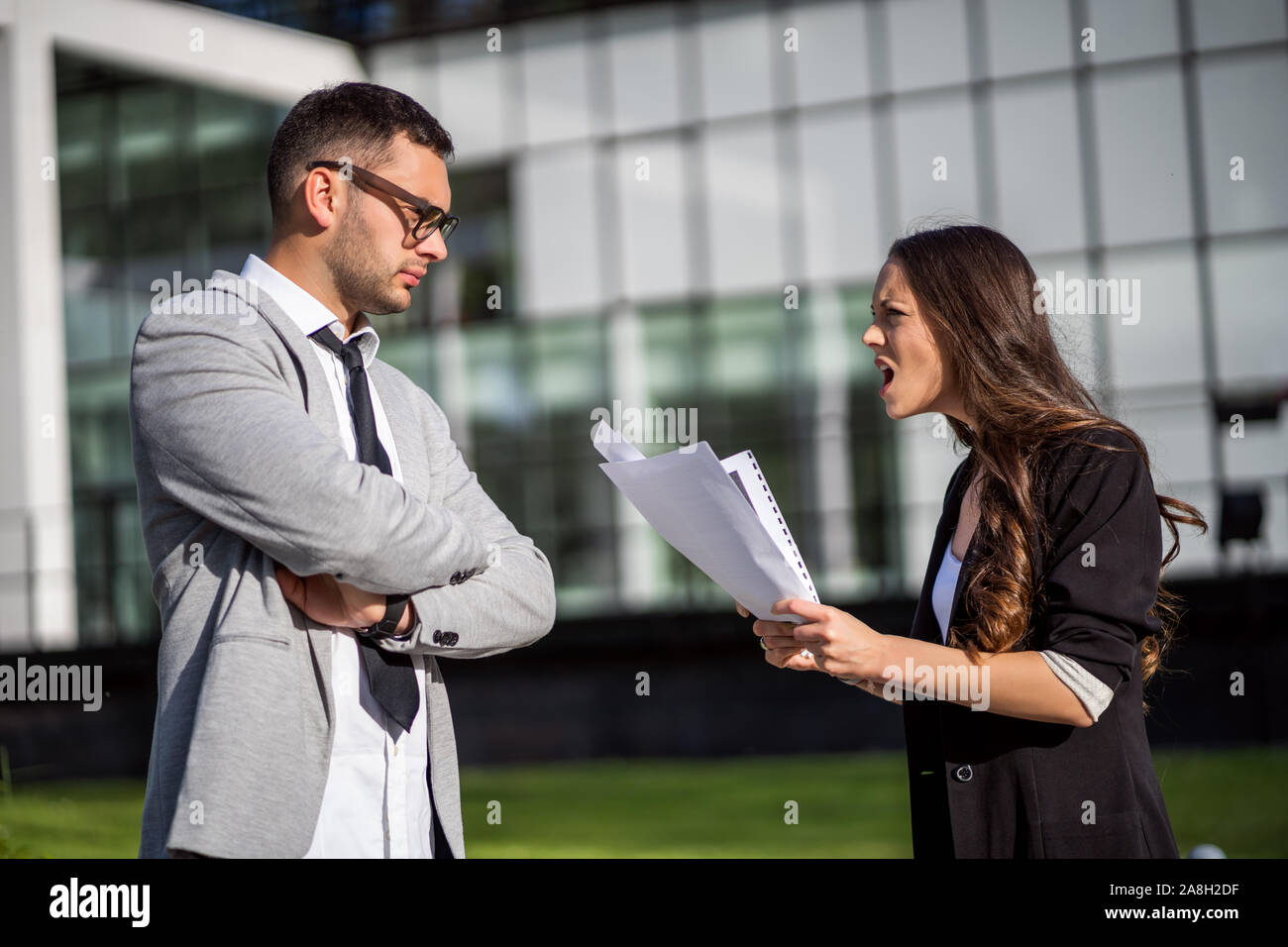 Business colleagues are arguing outside the company building. Stock Photo