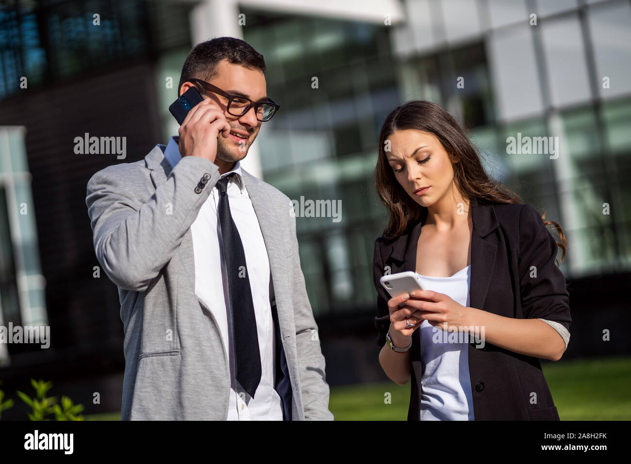 Business colleagues are communicating outside the company building ...