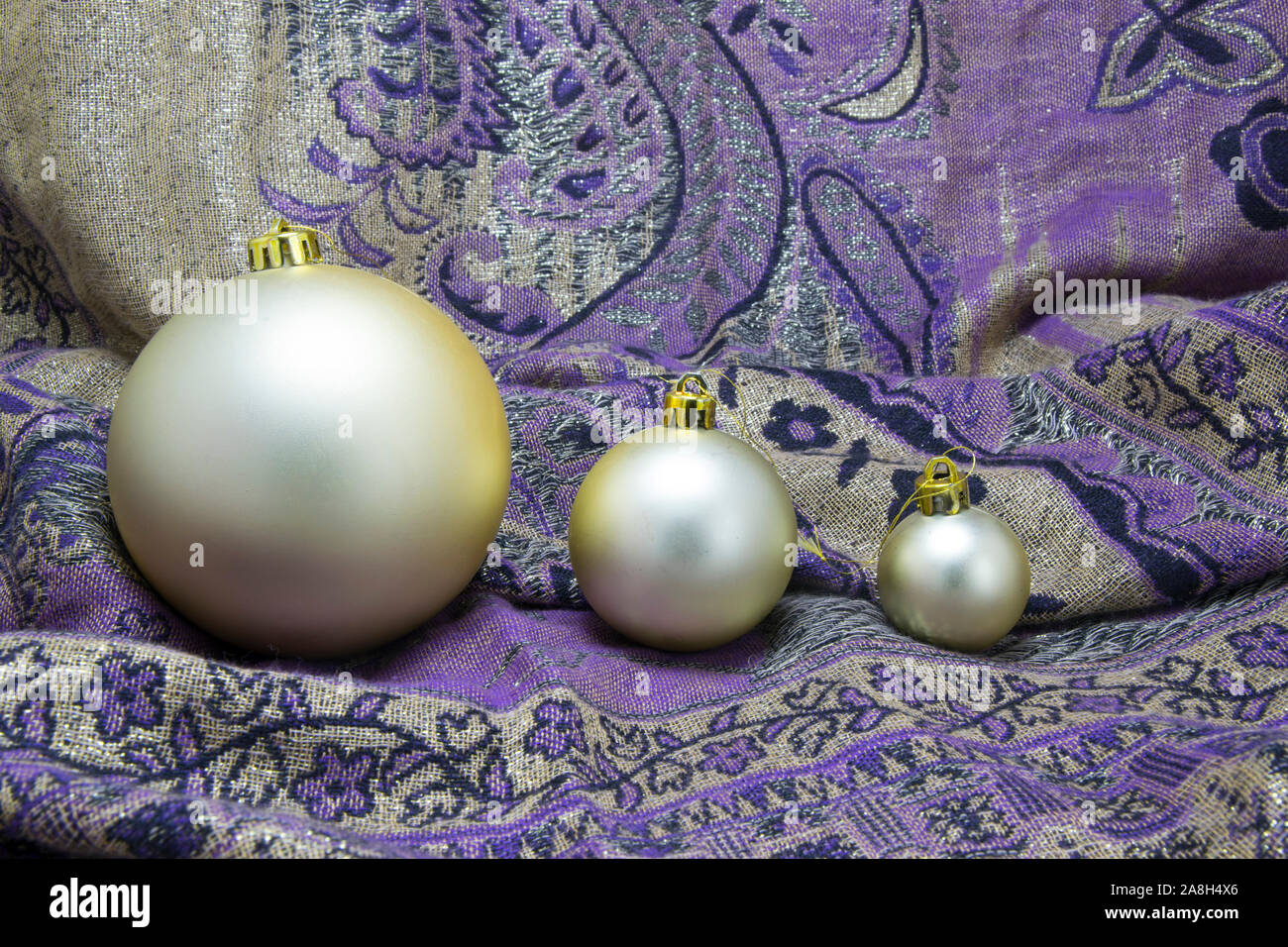 Golden baubles arrangement on purple textile Stock Photo