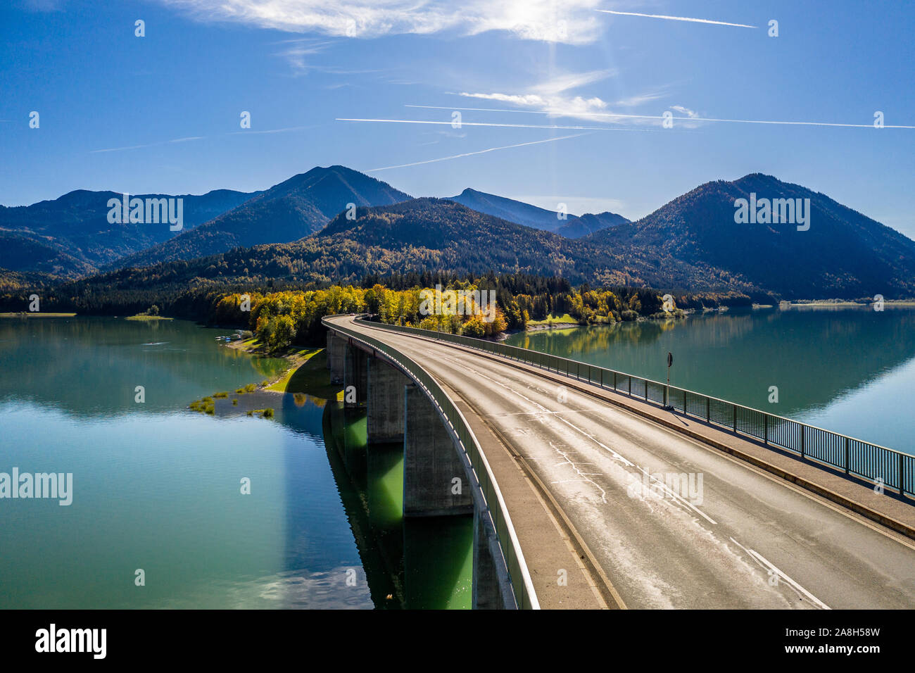Scenic aerial view of the bridge over Lake Sylvenstein with beautiful reflections. Alps Karwendel Mountains in the back. Autumn scenery of Bavaria Stock Photo