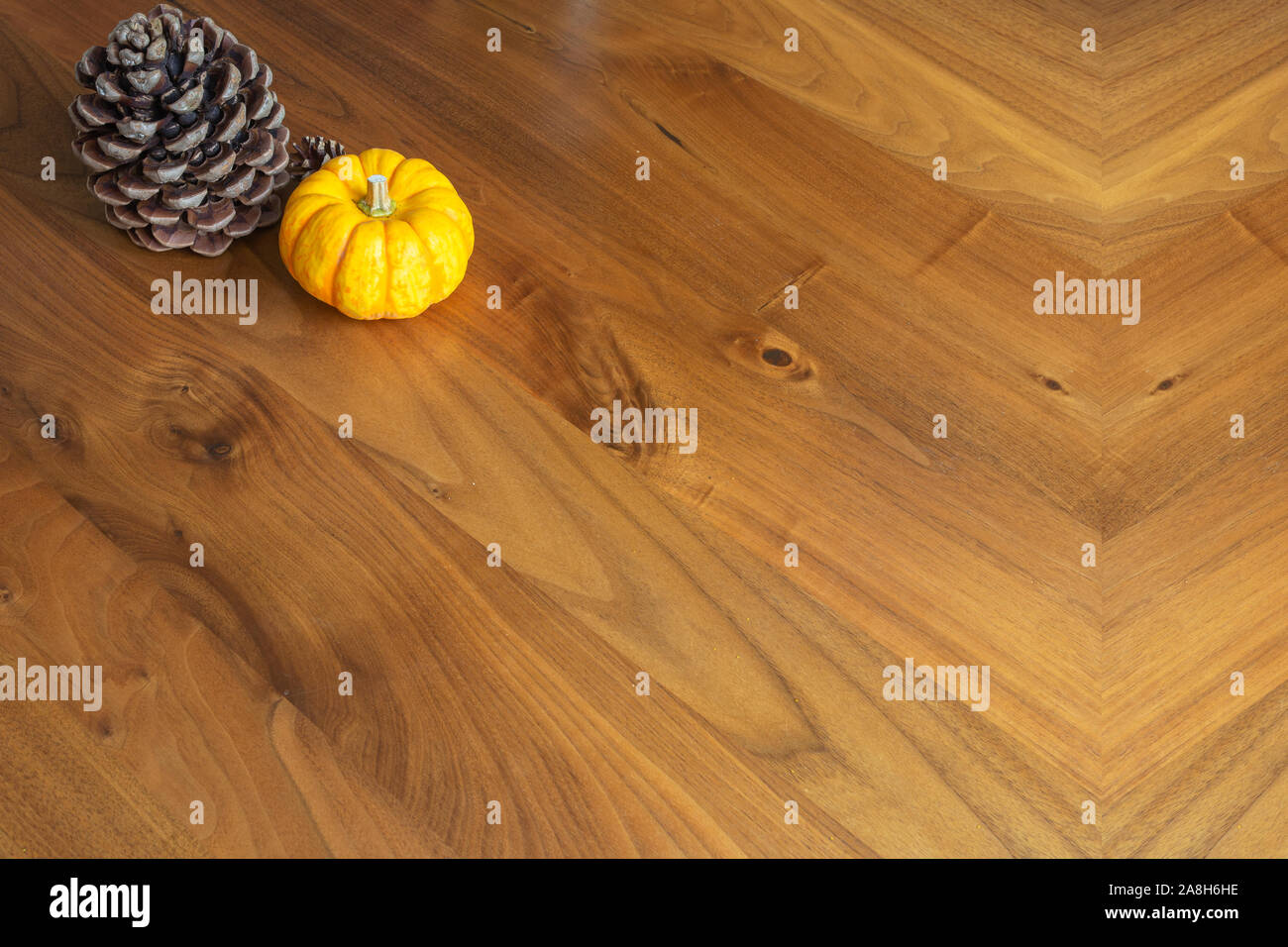 Orange Yellow Pumpkin With Pine Cone On A Brown Wooden Table
