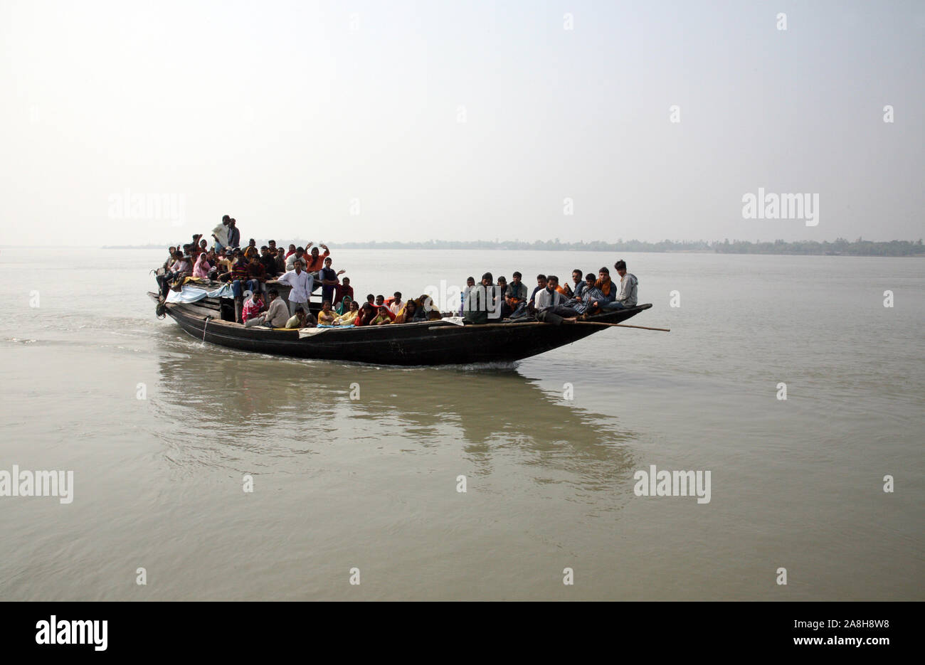 Wooden boat crosses the Ganges River in Sundarbans, West Bengal, India ...