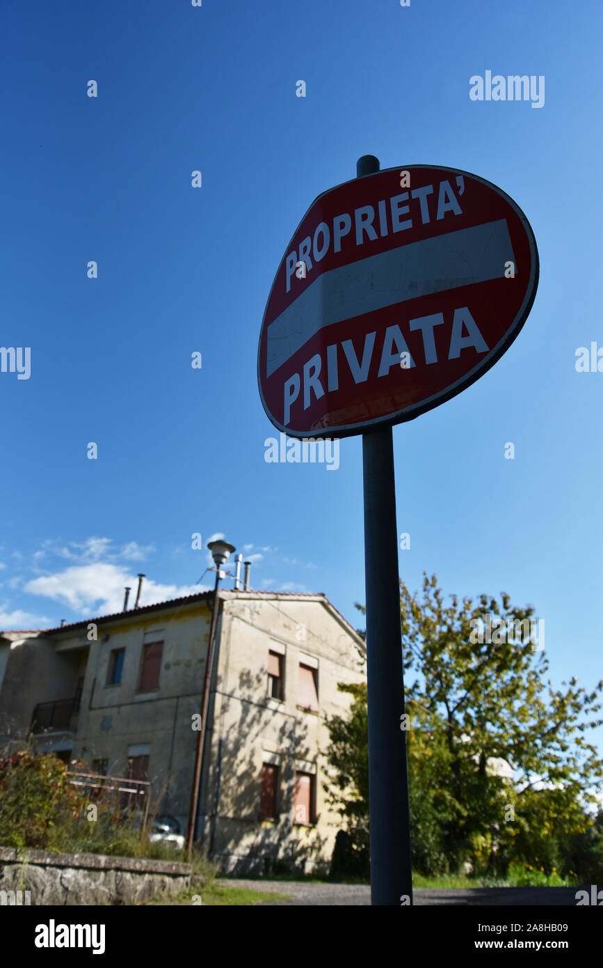 Red sign private property in Italy. A house in the background. Stock Photo