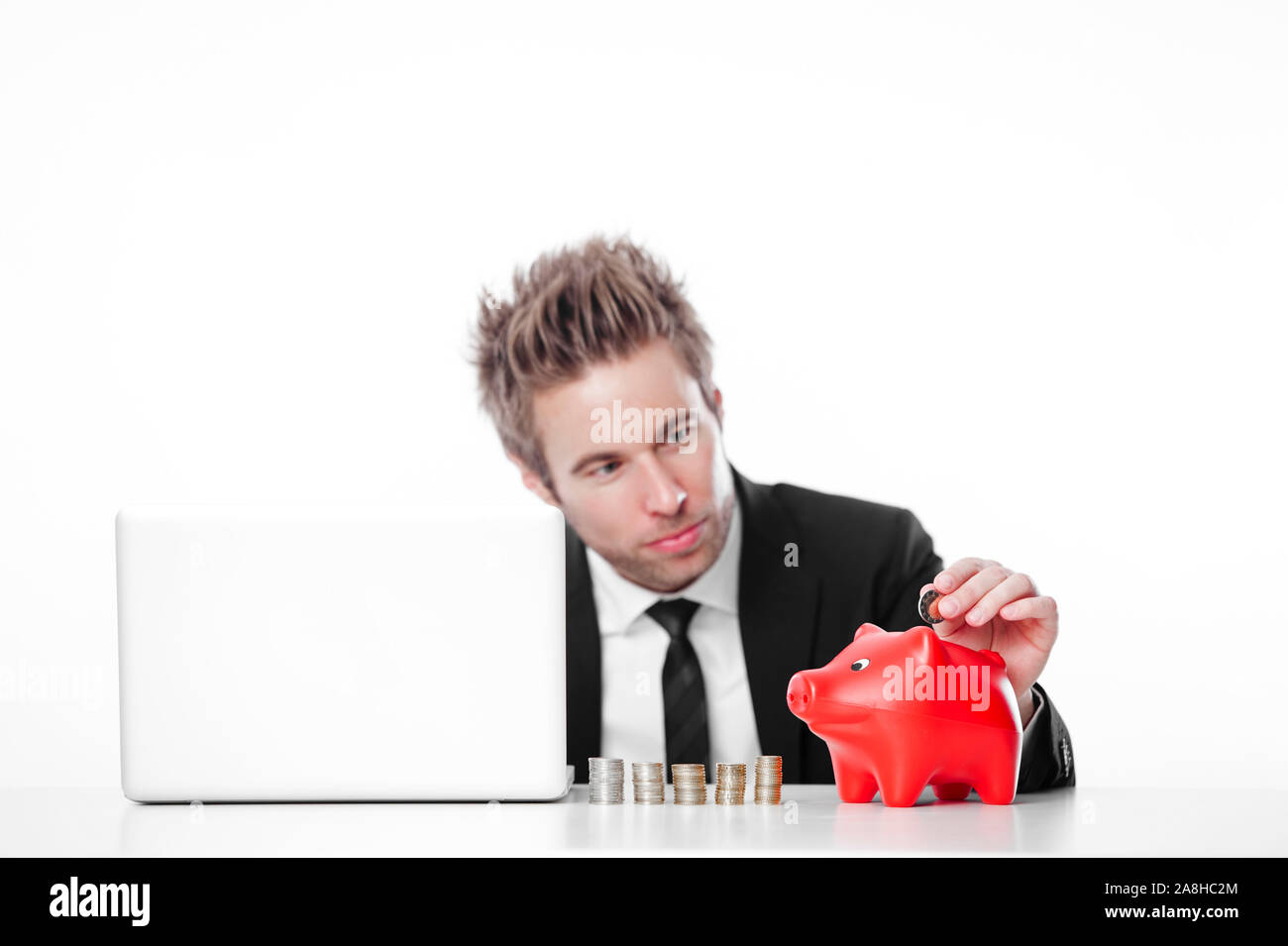 Vermögensberater, Symbolbild, mit Sparschwein und Laptop am Schreibtisch, Stock Photo