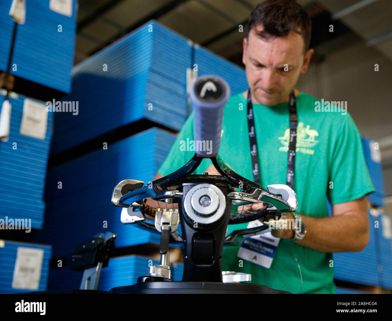 Astringer A stringer works on Ash Barty’s racquet before the finals kick off. Fed ...