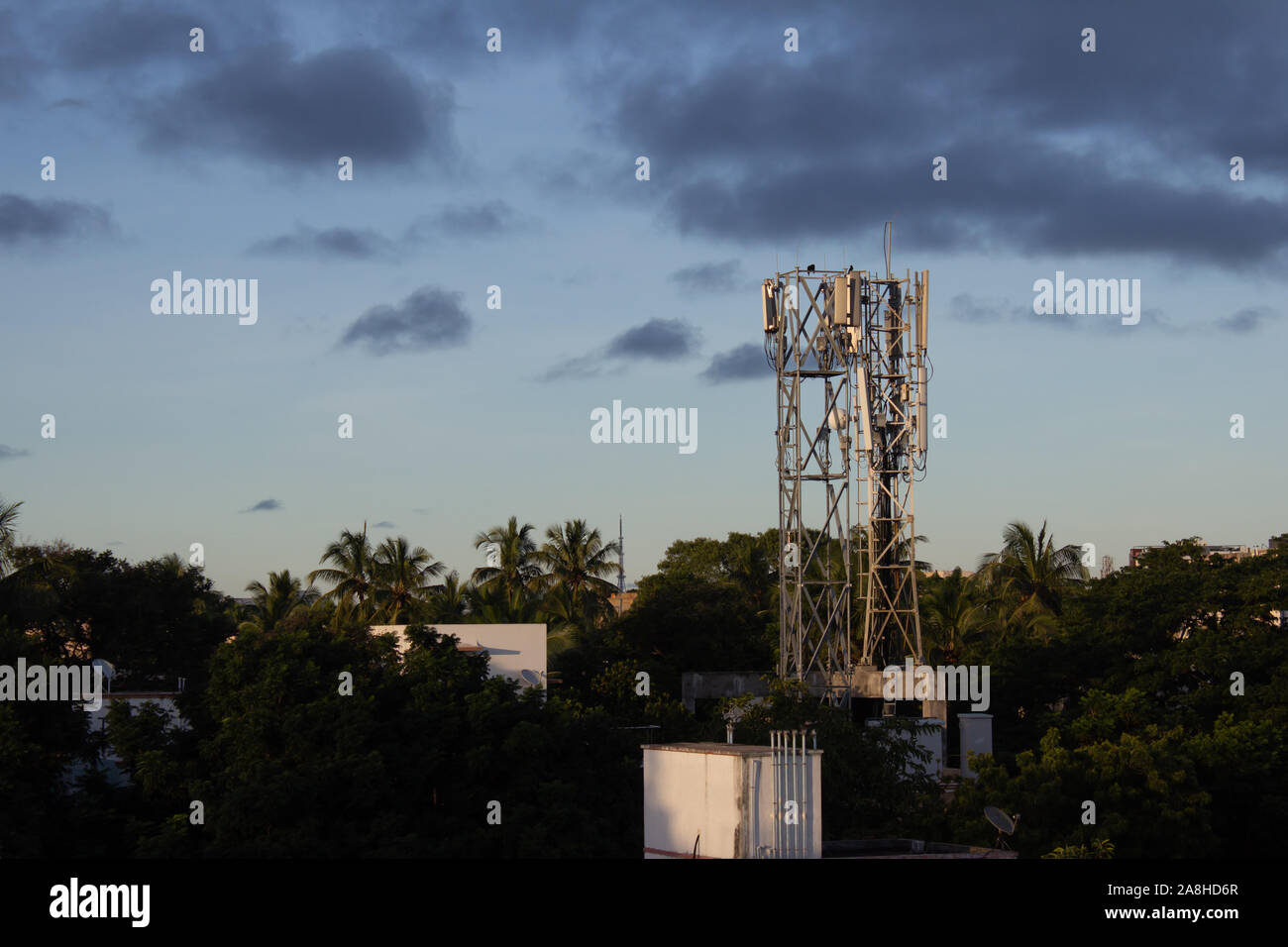 Cellular phone antennas on a building roof with sky background. Antennas for receiving and transmitting wireless signals. Stock Photo