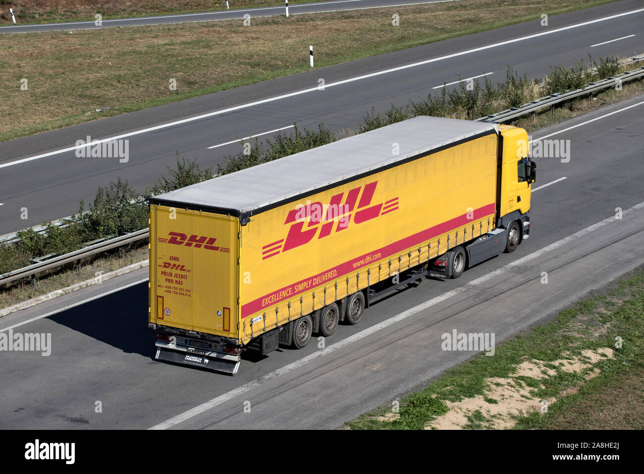 DHL truck with curtainside trailer on motorway. Stock Photo