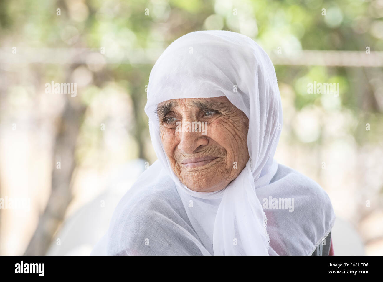 A beautiful, elderly lady wearing a white hajib, living a semi nomadic lifestyle in a village in Turkey Stock Photo