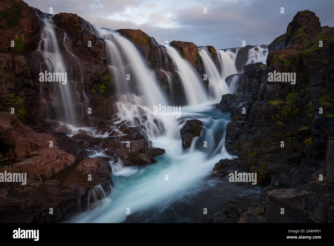 One of my favorite waterfalls in Iceland. Red rocks and blue water. Amazing contrasts... Stock Photo