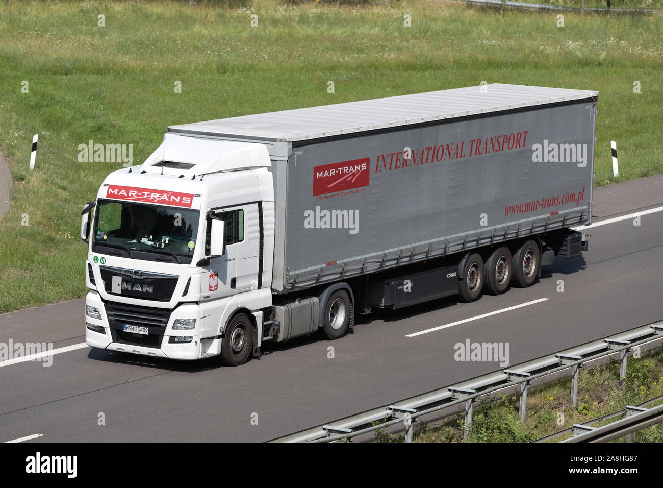 Mar-Trans MAN TGX truck with curtainside trailer on motorway. Stock Photo