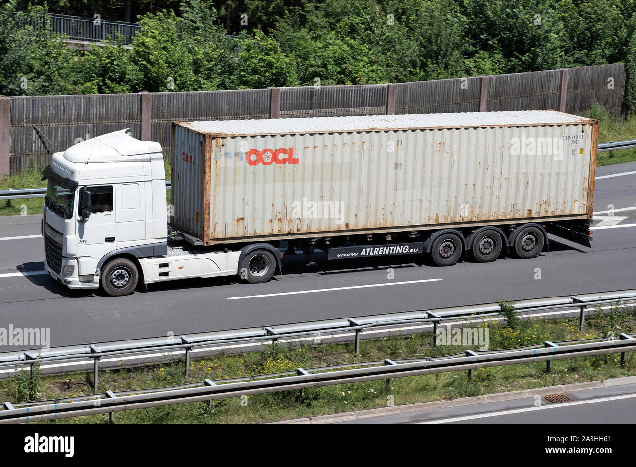 DAF XF truck with OOCL container on motorway. Stock Photo