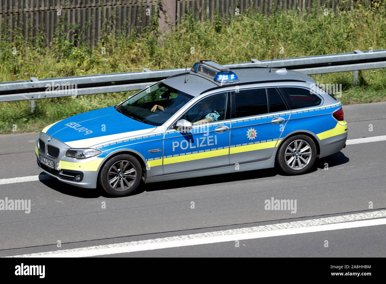 North Rhine-Westphalia state police car with active blue emergency vehicle lighting on motorway. Stock Photo