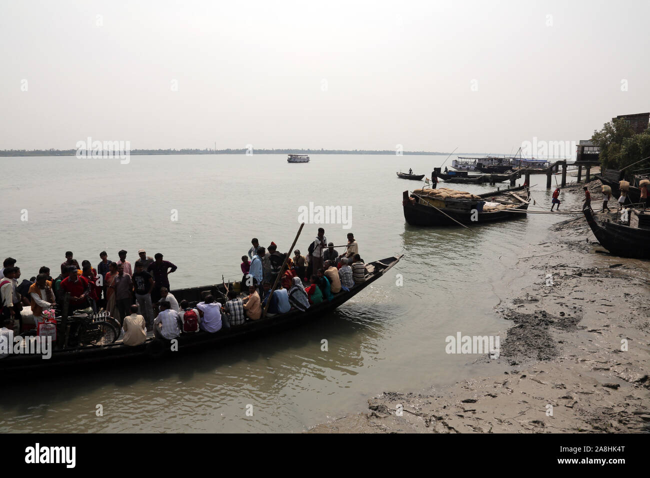 Wooden boat crosses the Ganges River in Gosaba, West Bengal, India